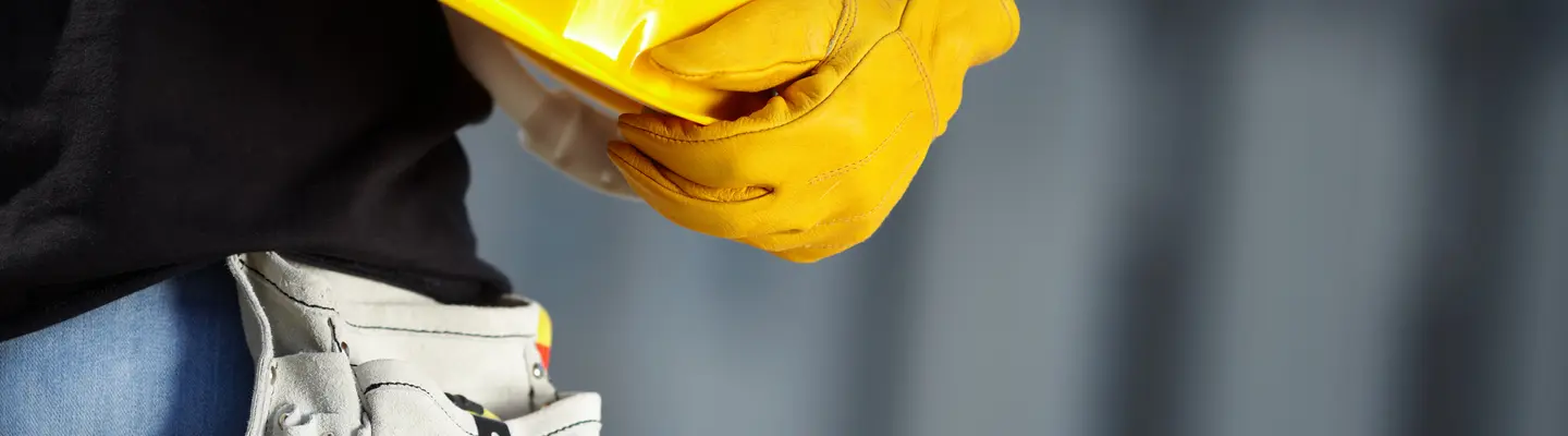 man holding hard hat wearing gloves