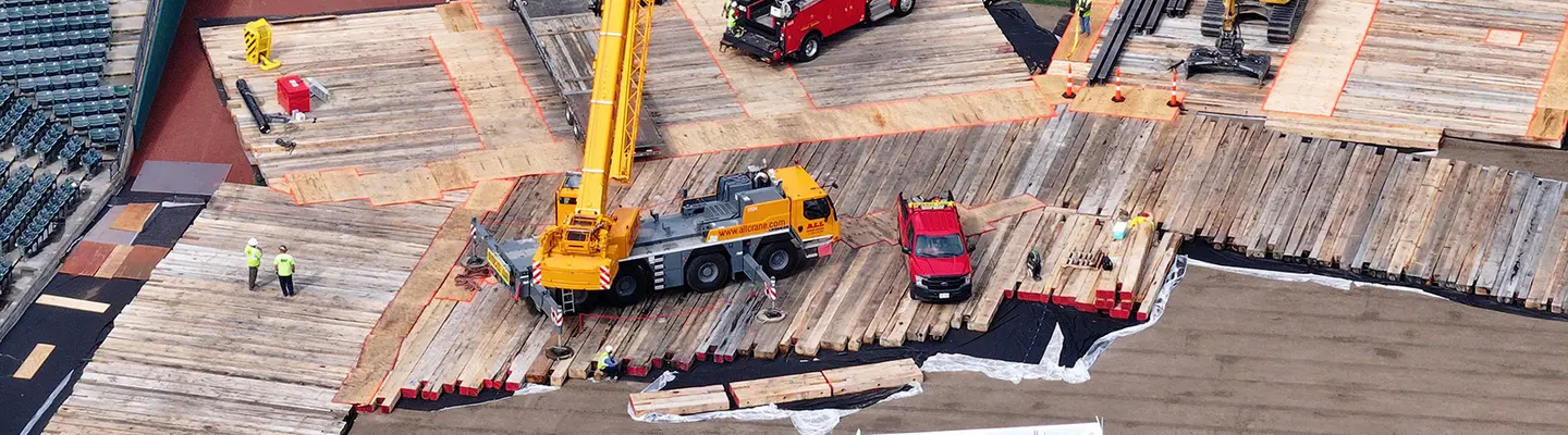 Timber mat supporting a crane at a jobsite