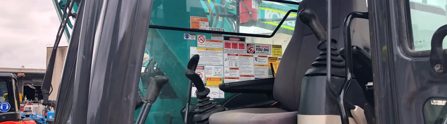 Competent operator skillfully controlling an excavator at a construction site focused on installing safety barriers.