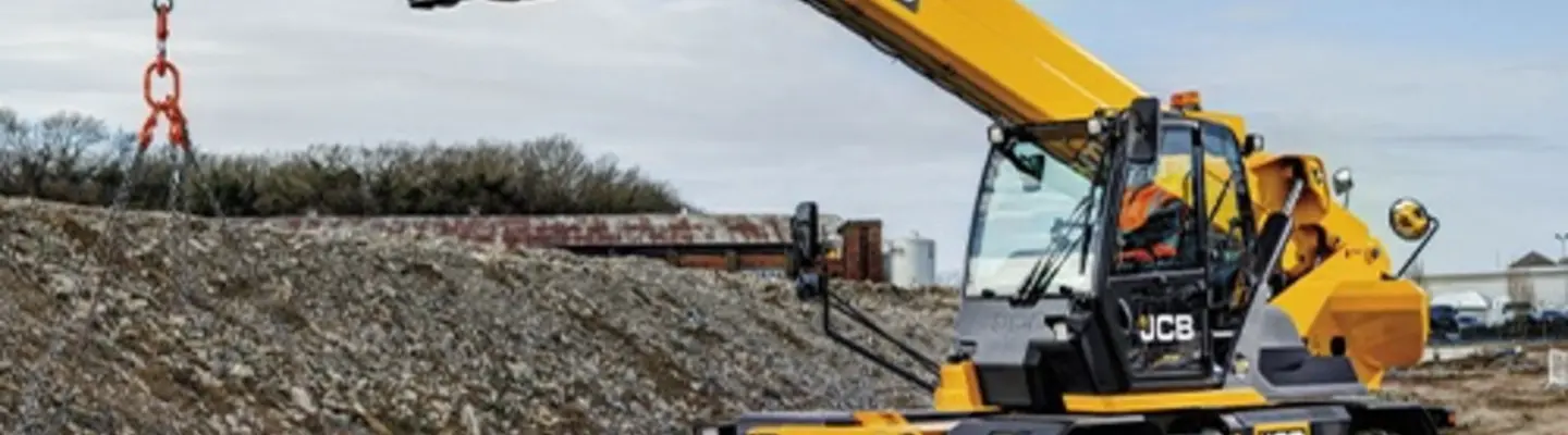 Worker operating machinery at a construction site during safety barrier installation to improve roadside protection.