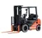 Front angled view of an orange and black Toyota warehouse forklift with a black mast, orange forks and an open cabin.