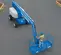 Top angled view of a lowered blue Genie articulating boom lift with a worker in the basket parked on pavement.