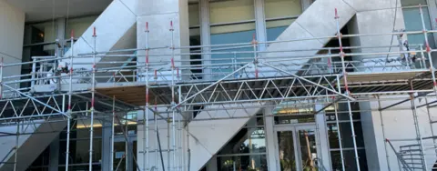 scaffolding in front of steps outside of an office building