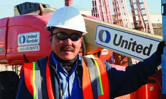 man in construction ppe next to boom lift