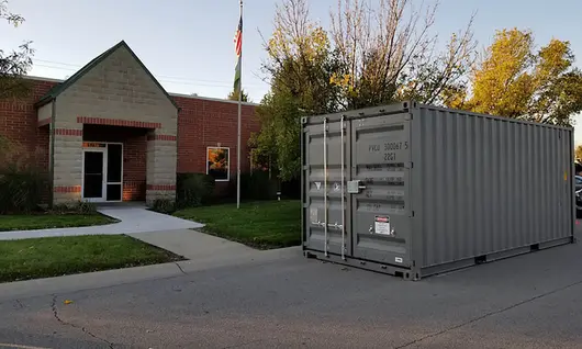 Storage container sitting in front of a building