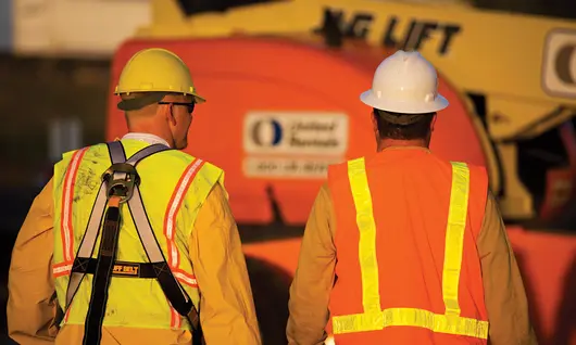 Two workers wearing personal protective equipment