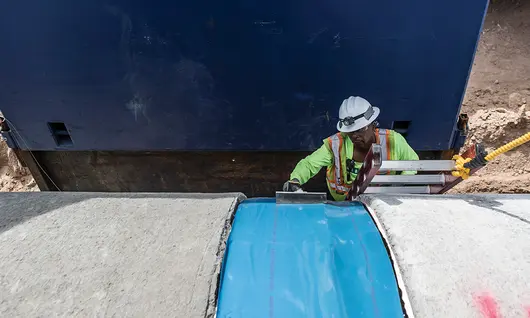 Worker in a trench wearing PPE