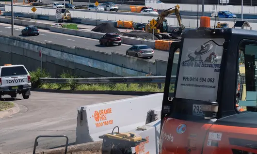Various types of roadside safety barriers installed along a highway to protect drivers and pedestrians.
