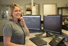woman standing by desk talking on phone
